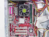MSI K8MM motherboard close-up showing AMD Sempron CPU with heatsink fan, DDR RAM slots, PCI slots, and VIA chipset