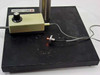 Bausch & Lomb optical platform base — Bausch & Lomb label visible, rotary intensity controller, illuminated point source lamp glowing on black granite base