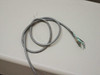 Gray cable with insulation stripped and inner conductors frayed and splayed at one end — included accessory cable showing damage