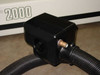 Black connector block assembly with corrugated cooling hoses attached on both sides and brass coolant fitting, Series 2000 label visible in background