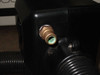 Close-up of brass coolant water fitting on connector block showing green verdigris oxidation/corrosion inside the fitting bore