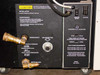 Varian 323-0012 rear panel close-up — water supply and helium return fittings, installation and maintenance caution label, Remote/Local switch, Remote Start, Status indicators, and power requirements placard