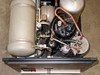 Varian 323-0012 Cryocompressor 2.1 top-down internal view — compressor motor, adsorber cylinder, copper lines, accumulator tank, and front control panel visible with top panel removed