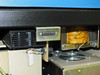 Underside of work surface showing D-sub connector (approx 25-pin), transformer, and cooling fan