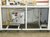 Rear undercarriage view of BF-200 with cabinet doors open showing tape reel drive assembly and wiring harnesses