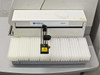 Jarrell Ash autosampler front view showing sample rack tray with white foam tube holders and probe arm