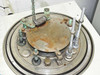 Close-up of Auto 500 chamber base plate showing heavy surface oxidation, source mounting posts, and wire connections