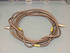 Coiled system cable with yellow-tagged Lemo/circular connectors on both ends — HNVS system interconnect cable laid on blue equipment chassis