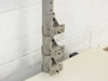 Close-up of vertical column height adjustment clamps showing three stacked bracket locking mechanisms