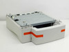 HP C8055A 500-Sheet Paper Feeder rear-left view with tray open, orange protective shipping tape still in place on the tray body
