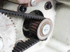 TC47 drive train close-up — toothed timing belt engaged on small sprocket with idler tensioner