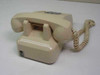 ITT Cortelco 250044-MBA-20M beige desk phone – rear three-quarter view showing handset cradle and coiled cord