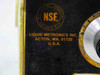 Close-up of Liquid Metronics Inc nameplate showing NSF Testing Laboratory certification, Acton MA 01720 USA address