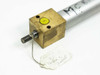 Close-up of front brass end cap with extended threaded shaft and yellow port plug; handwritten tag reading MC810 Tested and Passed visible