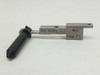 Actuator arm close-up showing machined aluminum slide, mounting holes, rubber-tipped plunger, and red ink markings