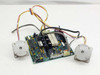 ADIC 17-1076-01 PCB assembly with two stepping motors laid out flat — rear/component-side view showing ICs, relays, and capacitors