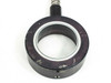 Close-up of ring housing front face on second unit showing heavier surface scuffing and paint wear on black anodized housing, small set screw visible at bottom
