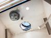 Interior ceiling of fume hood showing explosion-proof dome light fixture, round LED recessed light, and 10-inch round exhaust vent opening with ductwork collar