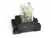 Omron LY4N-D2 24VDC general purpose relay seated in PTF14A DIN-mount socket — front-left view showing clear plastic cover and socket terminal markings