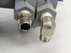 UE J400K-457 – close-up of 1/2 in NPT stainless pressure port fittings showing minor surface wear and oxidation