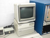 HP 9000 300 Series computer workstation with CRT monitor stacked on tower chassis — side view with Nano Instruments control cabinet visible at right