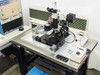Nano Instruments nanoindenter mechanical stage — full view on isolation table showing motorized XY stage, Olympus BH2-UMA microscope column, indenter head, and acoustical foam enclosure panels