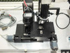Nano Instruments indenter head and motorized XY stage close-up — NANO-branded indenter assembly with motorized stage and BNC/coax cables