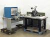 Nano Instruments Nanoindenter system wide view from rear — complete system showing blue control cabinet, HP 9000 workstation, indenter stage on isolation table, and manuals/binders on table