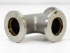 Stainless steel KF25 NW25 tee fitting — straight-on front view showing all three flanged ports in T configuration; discoloration and light oxidation visible on flange faces