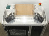 Uni-Solar MX1-711-000-5 corner trim machine — top-down view showing dual cutting head assemblies, flat work surface, and red emergency stop button