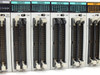 Four NAIS FP2-X64D2 64-point input modules and one Y64T output module closeup — showing 24V DC markings, CN1/CN2 ribbon connectors, and status indicator rows