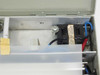 Interior closeup showing fluorescent lamp ballast with label, wiring, and mounting hardware inside electronics bay
