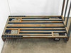 Top-down view of Cost Cutter cart 59x29 slatted steel and wood deck showing surface rust, chipped blue paint, and caster mounting plates