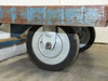 Close-up of two solid rubber swivel casters on Cost Cutter industrial delivery cart showing tread condition and axle hardware