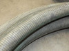 Close-up of corrugated flexible hose body showing surface wear and weathering along the length