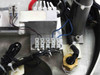Close-up of base platform wiring area showing terminal block, Kendrion solenoid connections, coiled cables, and brass fitting