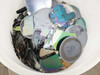 Close-up top view of tank contents showing whole wafers with iridescent thin-film patterns and broken wafer fragments