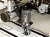 Close-up of sensor module mounted on PWS P5NMS probe arm, black rectangular unit with multi-conductor cable