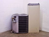 Carrier FB4ANF060 outdoor condenser and air handler — rear/side view showing condenser fan guard and back panel of air handler