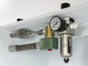 Close-up of top-mounted pressure regulator assembly showing inline pressure gauge, filter/separator bowl, Whitey valve, stainless fittings, and green solenoid or check valve