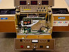Tegal 701D overall front view with lower panel open showing internal control PCBs, motor assembly, three digital displays on top, load and unload cassette stations visible