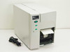 Zebra TLP2746E thermal label printer – front and left side view with power cable and label partially fed