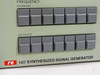 RE 107 Synthesized Signal Generator front panel detail — close-up of FREQUENCY INCREASE and DECREASE pushbutton rows and RE 107 SYNTHESIZED SIGNAL GENERATOR nameplate badge