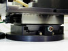 Underside of XY linear stage rotary base showing stage rail, pneumatic fitting, and mounting hardware