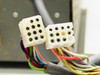 Close-up of two white ceramic multi-pin IDC connectors on cable harness connecting control panel to power supply