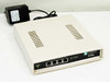 Cayman 3220-H DSL Router front three-quarter view showing front panel with 4 LAN 10BT ports and DSL-Status indicator, with APS power supply alongside
