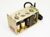 Transistor Devices Inc SPS 1676 switching power supply – three-quarter front view showing open frame chassis, top-mounted TO-3 transistors, transformer, and hardwired AC cord