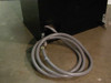 Hevi-Duty HDT-5610 cabinet base rear — gray flexible conduit power cable assembly coiled on floor, cabinet on casters with mounting brackets visible