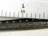 Strip of 10 Fairchild MMBT2222AR-R R2T SOT-23 transistors on tape shown next to ruler for scale