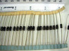 Lot of STMicroelectronics P6KE6V8A TVS diodes banded together in a row on tape strip with ruler showing scale